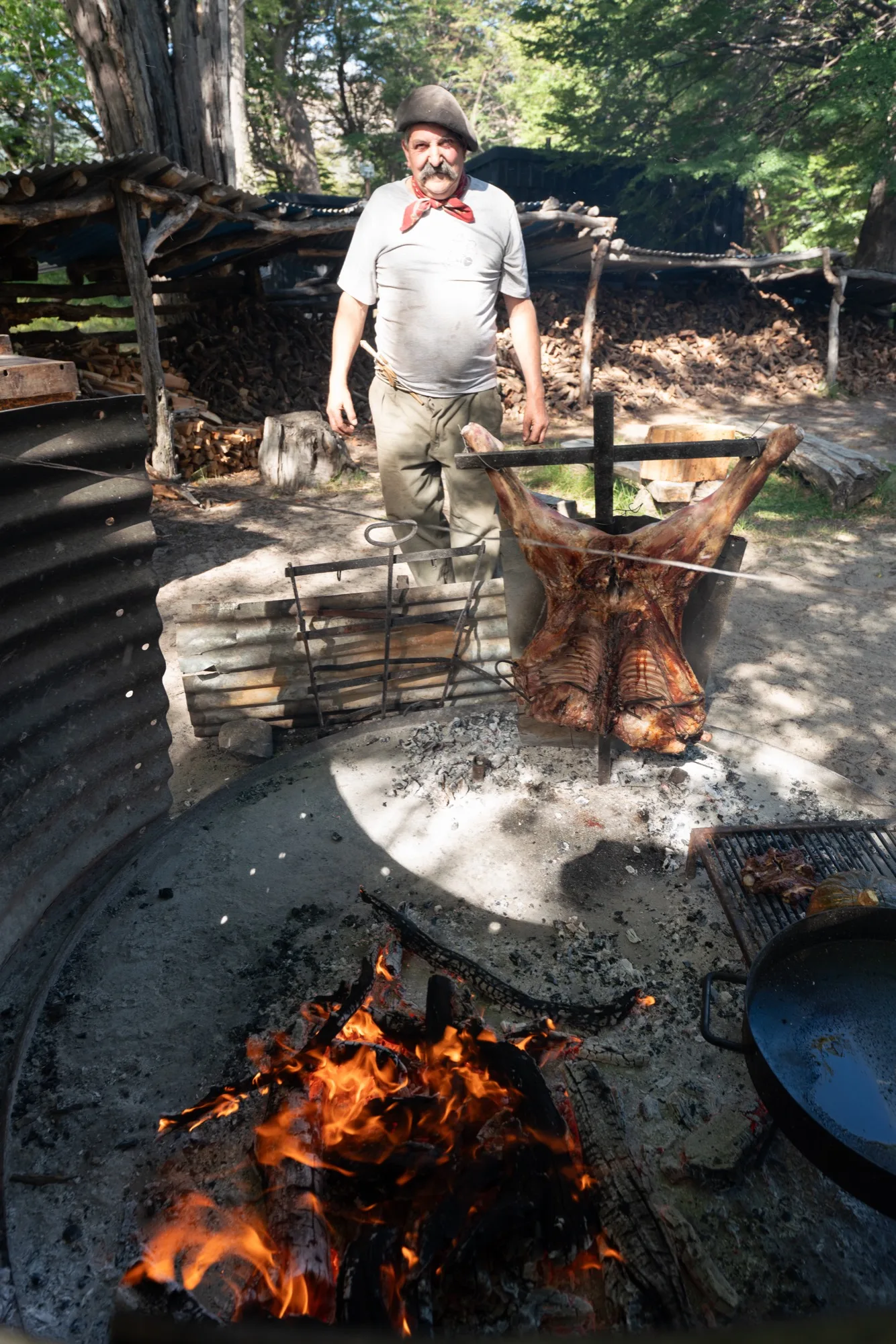 El asador junto al cordero en la cruz, sobre el fuego
